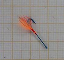 Мушки на корюшку в Де Кастри на синих крючках с длинным цевьем Маруто № 3.6 мм с бородкой делковая Вата Атлас и люрексом огненная плазма фирмы Гадлайнер. Огненная точка атаки  мушка морковка на корюшку